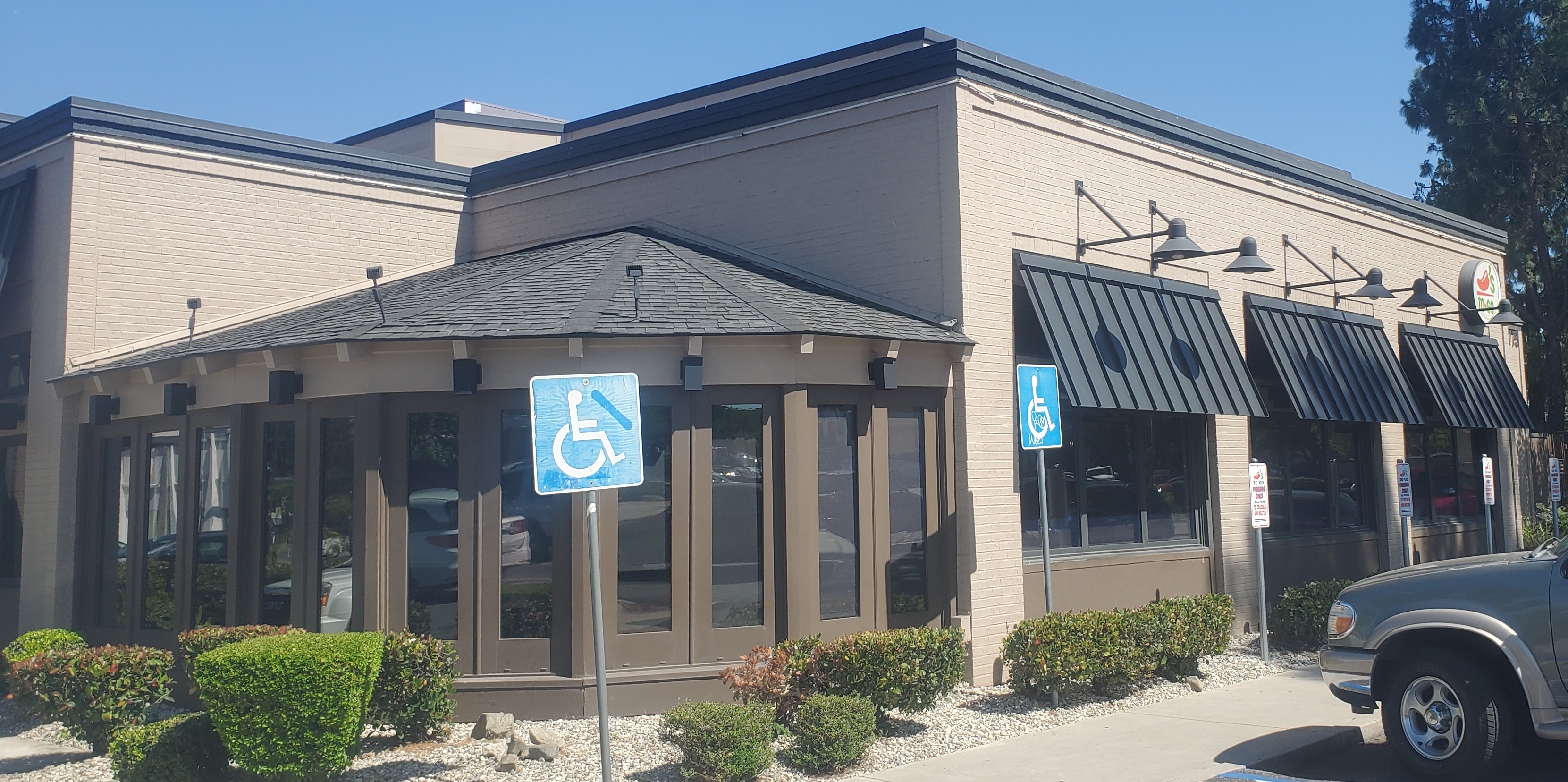 Black standing seam metal awnings on a stucco restaurant building in Encino