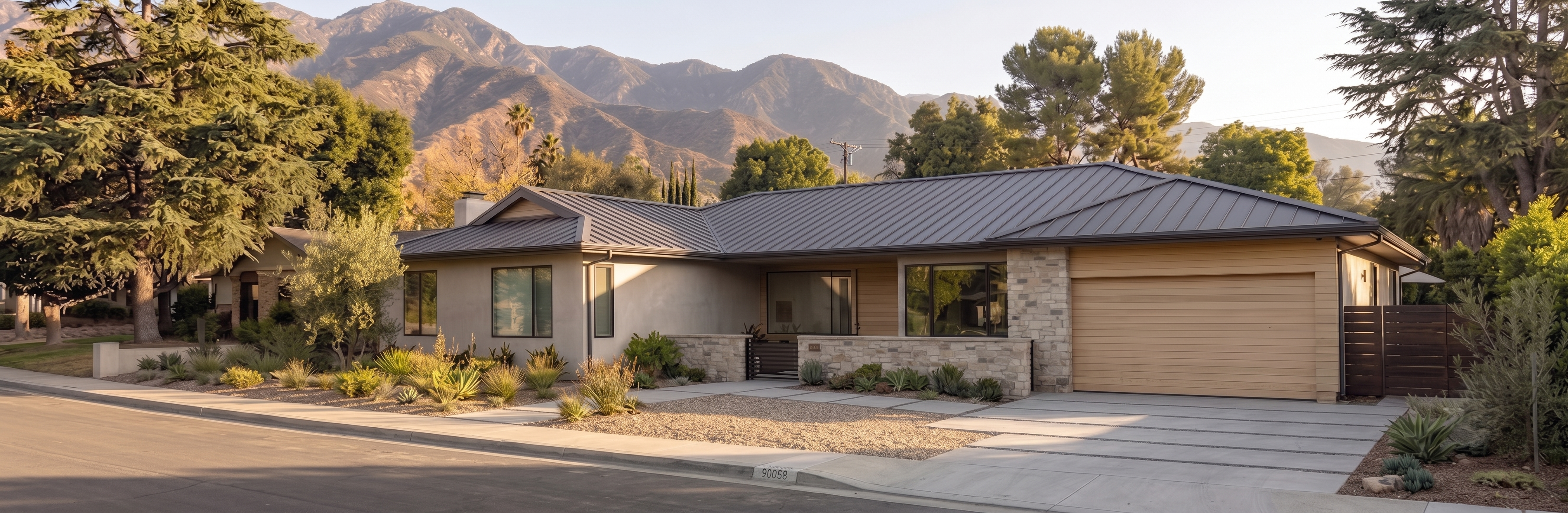 Charcoal standing seam metal roof on a single-story mid-century modern ranch with wood garage below the mountains in Altadena