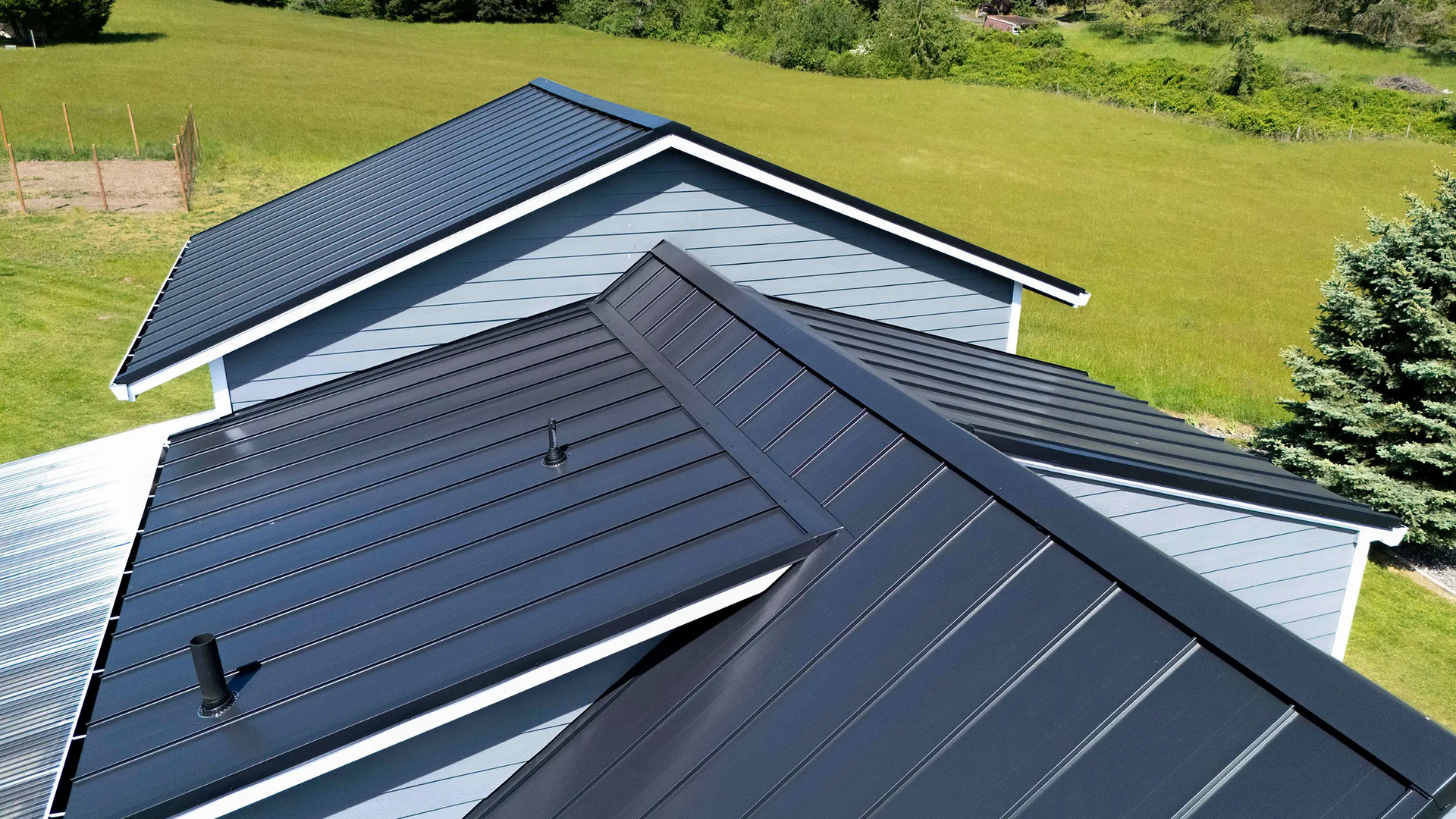 Aerial view showing long continuous standing seam panel runs on large residential roof