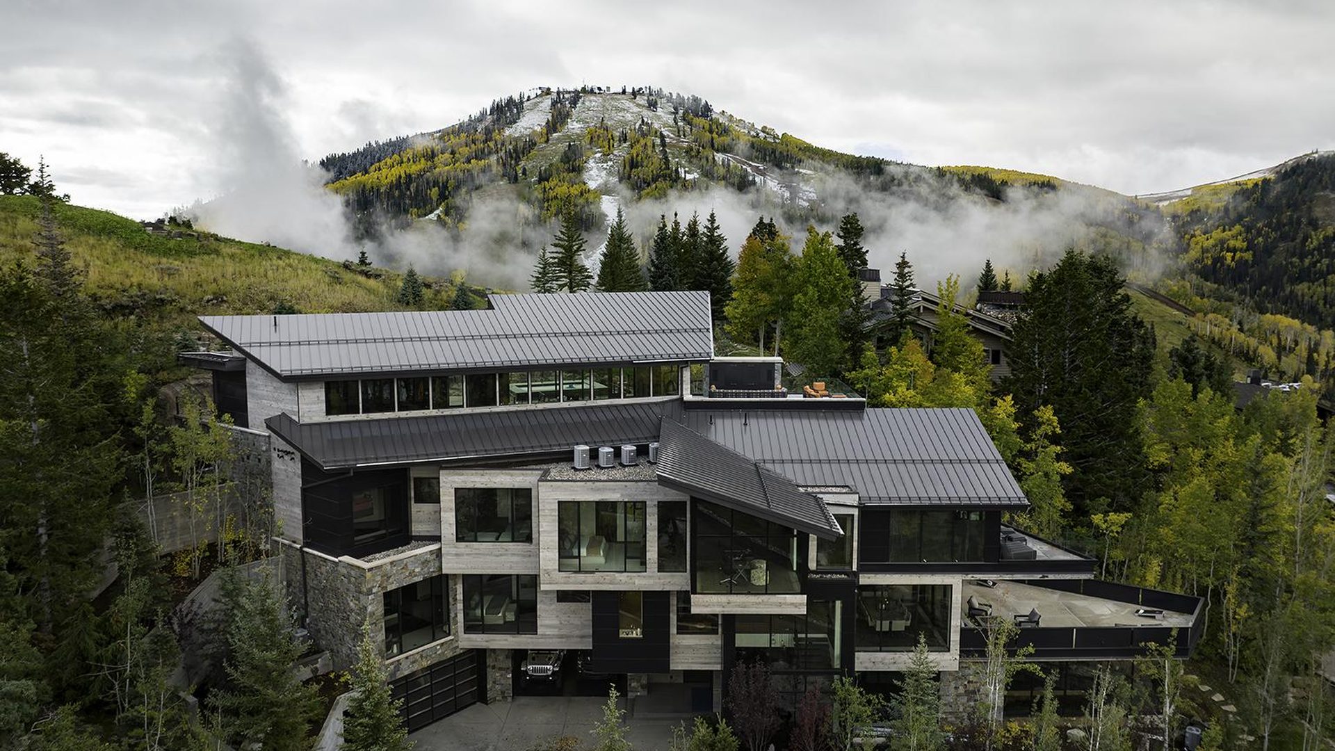 Luxury estate with charcoal gray standing seam metal roof and premium craftsmanship