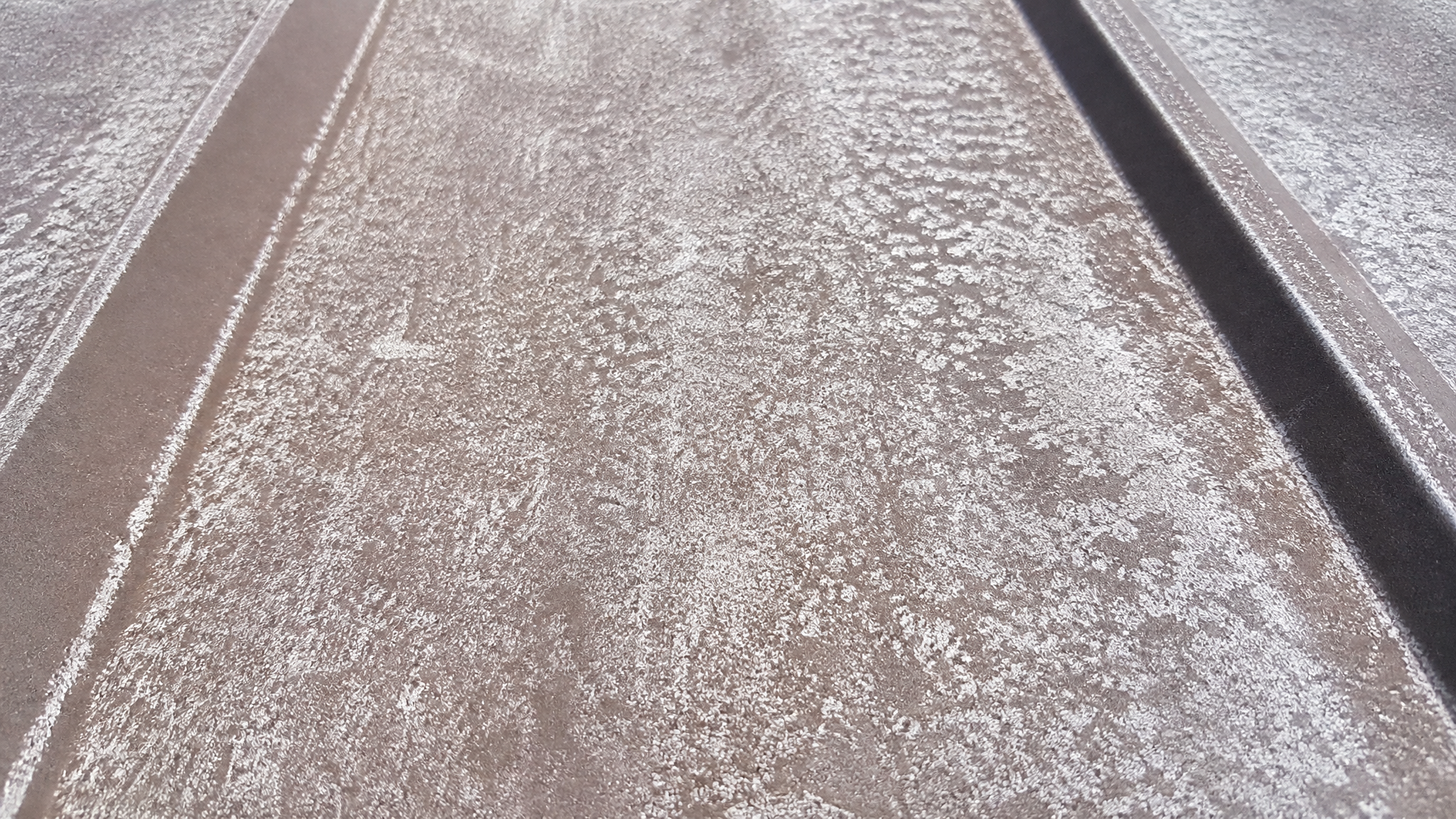 Chalking and fading on an SMP-coated metal roof after years of Southern California sun
